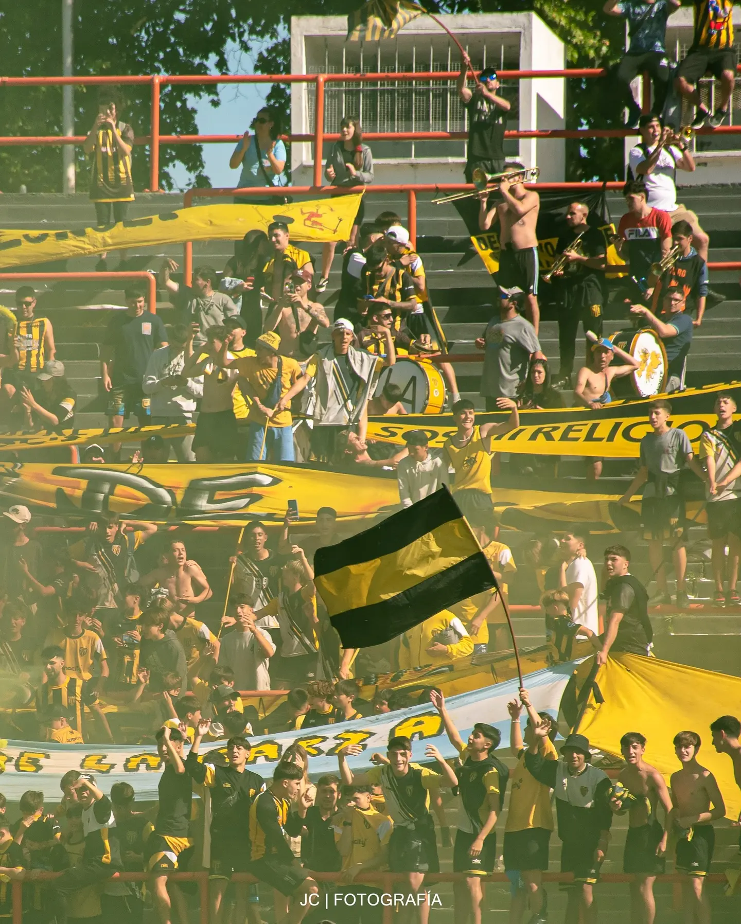 Hinchada de fútbol celebrando en un estadio